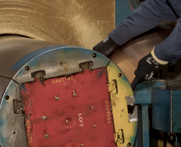 A worker loading a machine with copper material